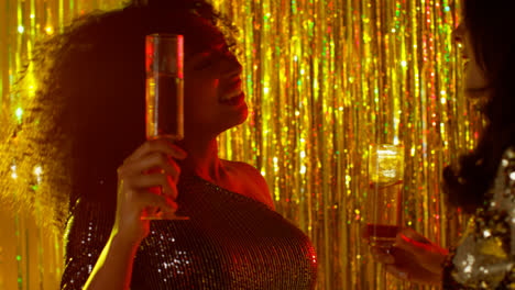 Close-Up-Of-Two-Women-Dancing-In-Nightclub-Bar-Or-Disco-Drinking-Alcohol-With-Sparkling-Lights-15